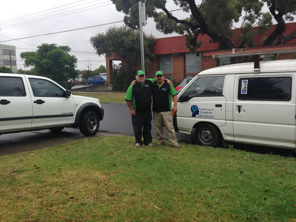 Two members of the Think Smart Plumbing team beside a branded work van